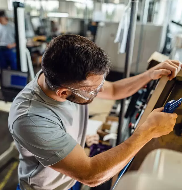 jovem-trabalhador-manual-trabalhando-na-maquina-industrial-em-uma-fabrica (1)